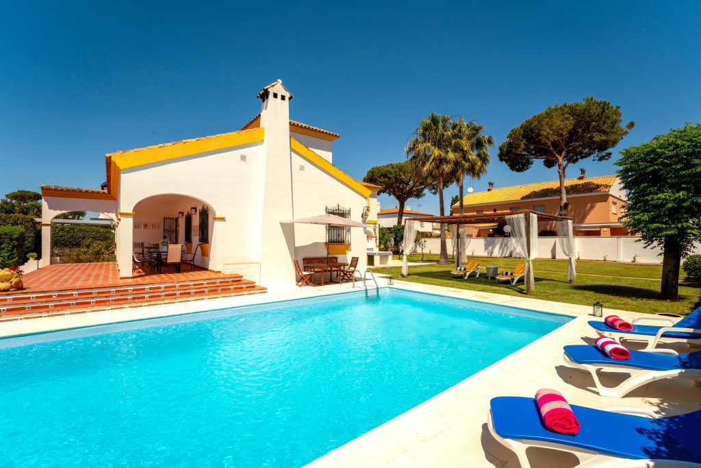 A private pool within a garden in villa la caleta with sunny blue skies
